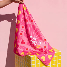 Foulard Amour & Soleil Soleil Mojito en satin rose, motif cœurs et fleurs, porté à la main