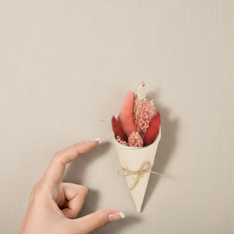 mini cone de fleurs sechées et mains pour comparer la taille