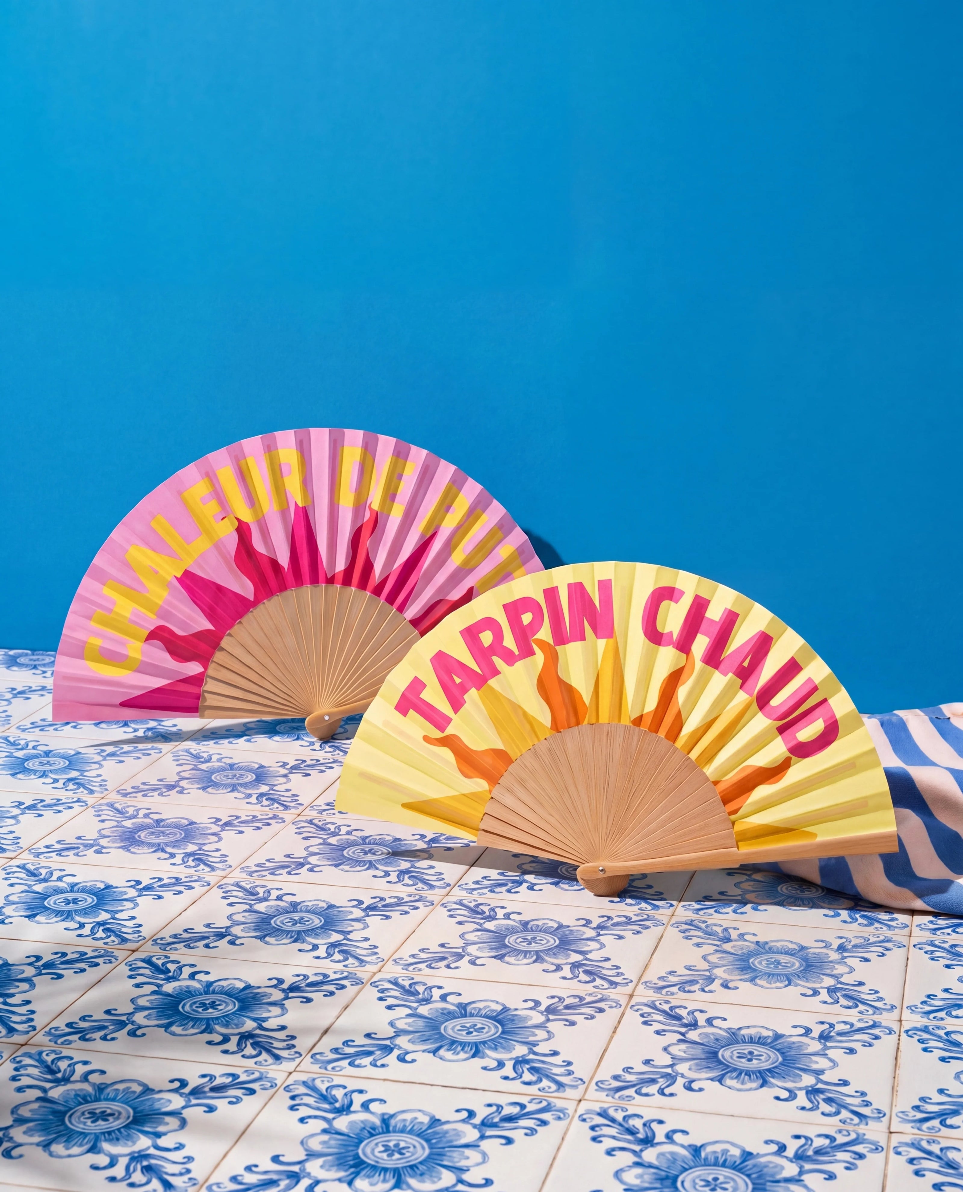 Éventails Tarpin Chaud et Chaleur de Pute Soleil Mojito posés sur carrelage bleu, collection été